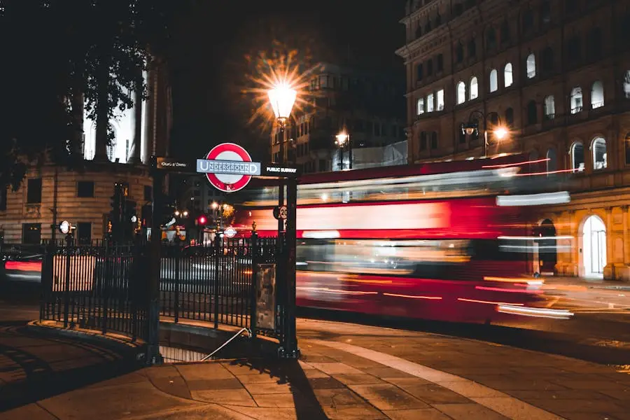 Dynamic night scene of a double-decker bus passing by an iconic London Underground entrance.